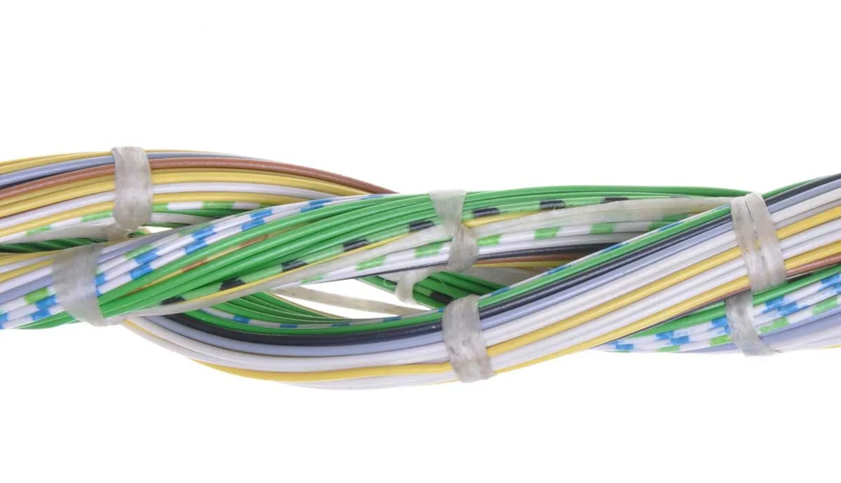 Close-up of twisted green, yellow, and white wires bundled with two zip ties on a plain white background.
