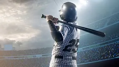 Baseball player wearing a pinstripe uniform with number 25 on the back stands ready to bat in a crowded stadium.